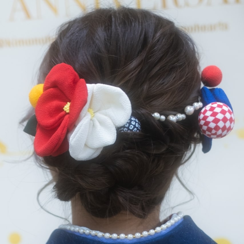 ちりめん生地で作られた紅白の椿と手鞠風の和玉。カラフルでポップな髪飾りでハイカラに。