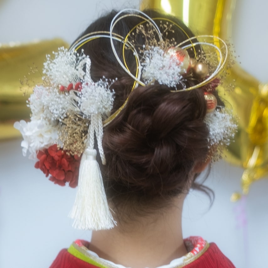 紅白、金の髪飾りがめでたい晴れの日にぴったり。白をメインに、花もドライな質感を選んで今っぽく。