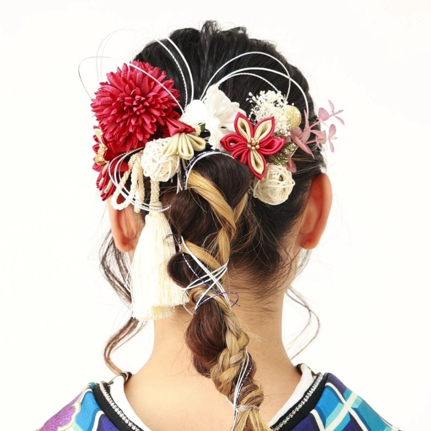 リズム感のある紐アレンジ。紅白の花とタッセル、水引をたっぷりと飾った、晴れやかなスタイル。