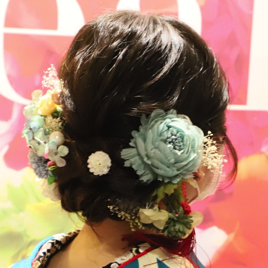 編み込みで結んだまとめ髪にパステルトーンのお花を飾ってガーリーに。甘く和らげなお姫様の出来上がりです。