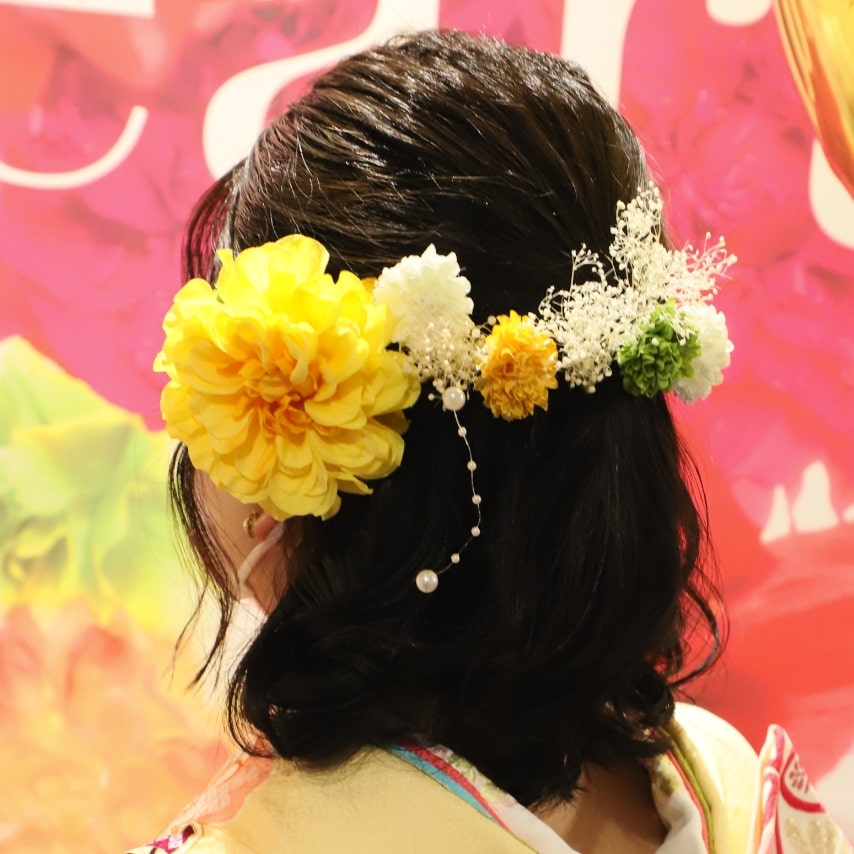 ふわふわに巻いた髪にビタミンカラーのお花を飾って多幸感溢れるイメージへ。和装でのダウンスタイルも、ミディアムレングスなら重みのある印象になりません。