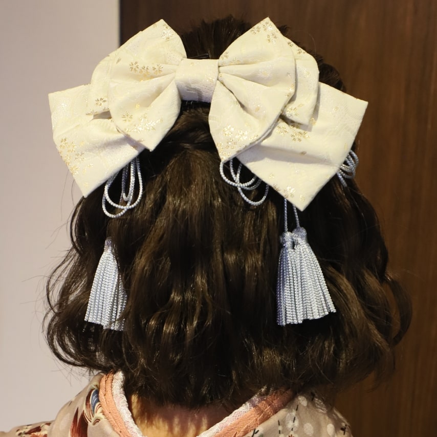 ゆるふわな巻き髪に大きなリボンでガーリーに。揺れるタッセルが特別感を演出してくれます。タッセルはアンティークなイメージもありますが、髪に飾ると和の印象も強まります。